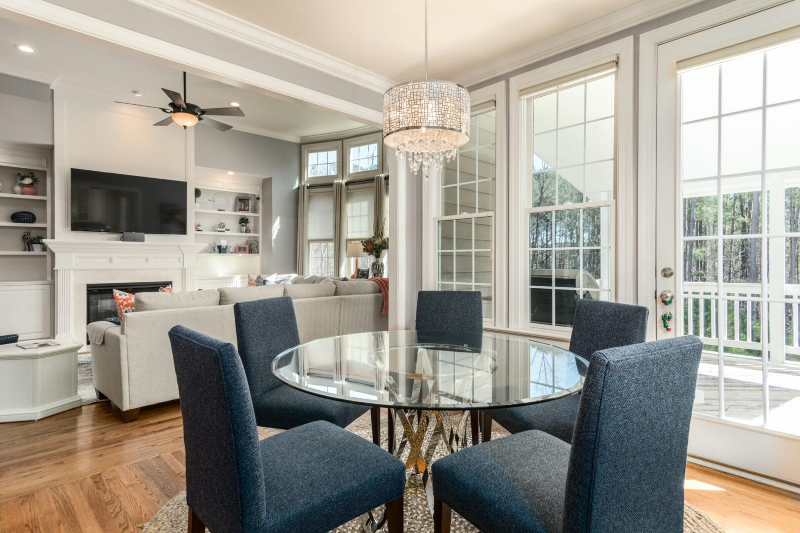 A dining room table with blue chairs and a chandelier.